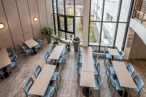 a room with tables and chairs and windows at Comfort Aparthotel Les Hauts d'Annecy in Annecy
