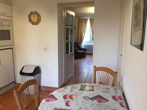 a dining room with a table and chairs and a kitchen at 4 Impasse de la Bataillerie in Oyes