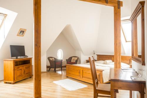 a bedroom with a bed and a desk and a tv at Villa A. Malka in Poděbrady