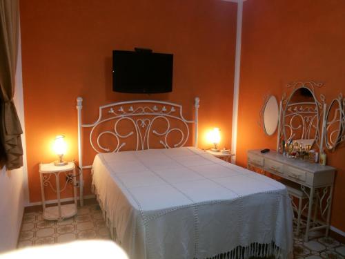 a bedroom with a white bed and two tables with lights at Casa em Itanhaém in Itanhaém