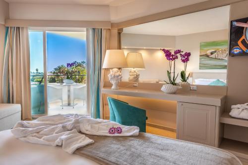 a bedroom with a desk and a bed with a view at Acacia Palace in Marina di Ragusa