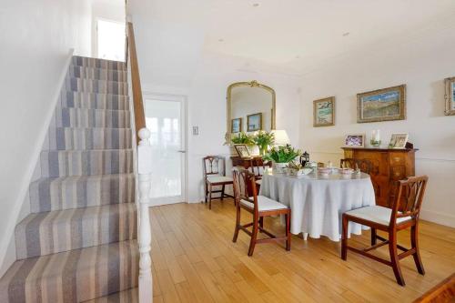 a dining room with a table and chairs and a mirror at Fulham B&B in London