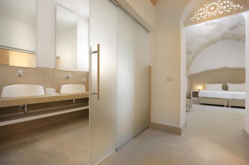 een badkamer met 2 wastafels en een bed in een kamer bij Masseria Donna Huga in Leverano