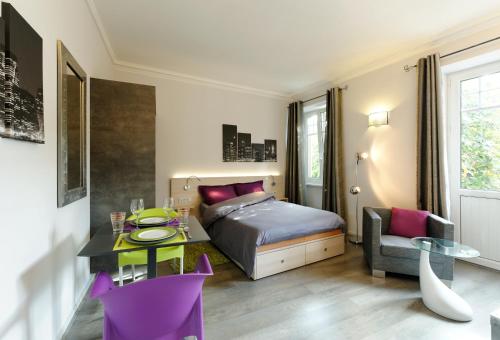 1 dormitorio con 1 cama, 1 mesa y 1 silla en Les Balcons du Rohan, en Saverne