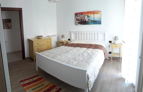 um quarto com uma grande cama branca e duas mesas em Alle Porte di Genova em Sant'Olcese