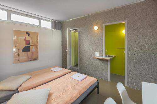 a room with a bed and a mirror in it at Lausanne Youth Hostel Jeunotel in Lausanne