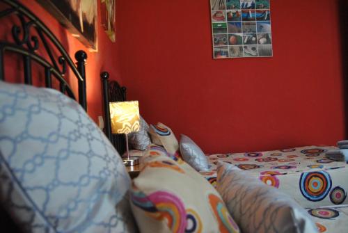 a bedroom with a bed with a red wall at Apartahotel Rural CollaRubio Luxury in Collado Mediano