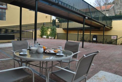 a table and chairs sitting on a patio at Apartahotel Rural CollaRubio Luxury in Collado Mediano