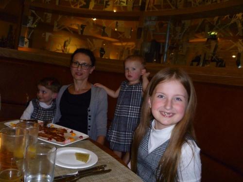 a woman and three children sitting at a table in a restaurant at Fairway Hotel in Bathgate