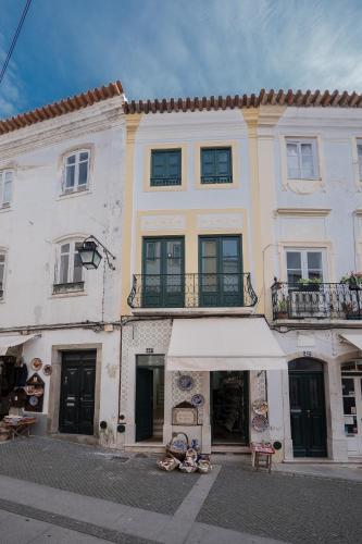 a large white building with awning in front of it at Home at Évora's Main Street in Évora