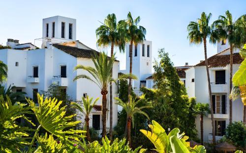 un edificio blanco con palmeras en el primer plano en Ona Alanda Club Marbella, en Marbella