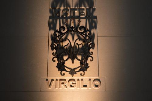 a sign that reads off virginico hanging on a wall at Hotel Virgilio in Tropea