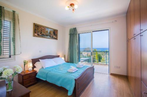 Un dormitorio con una cama y una ventana grande. en Latchi Marina View, en Neo Chorio