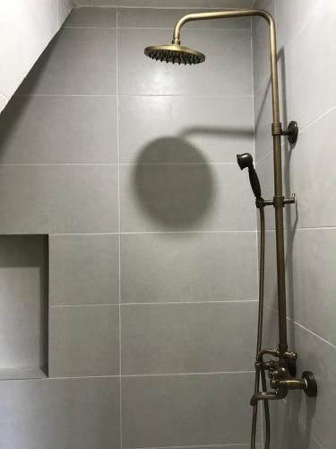 a shower with a shower head in a bathroom at Mimi House in Hoi An