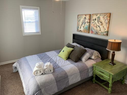 a bedroom with a bed with towels on it at The Orange Door-Sleeps 10 in Louisville