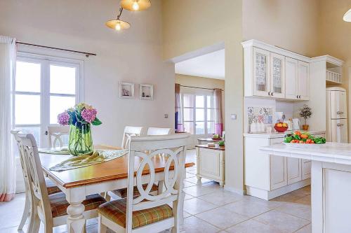 a kitchen with a table with a vase of flowers on it at Villa Nikolas in Andipáta Erísou