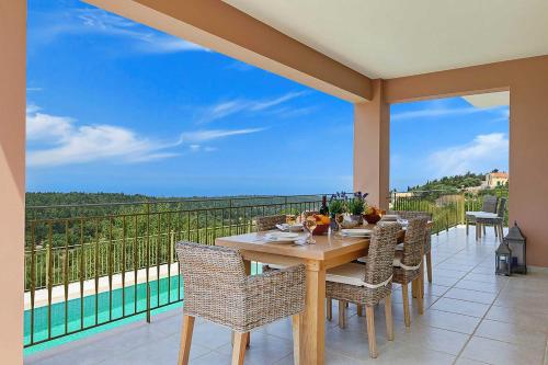 a table and chairs on a balcony with a view at Villa Nikolas in Andipáta Erísou