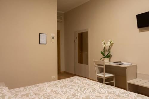 アレッツォにあるホテル チェッコのベッドルーム1室(ベッド1台、デスク、コンピュータ付)