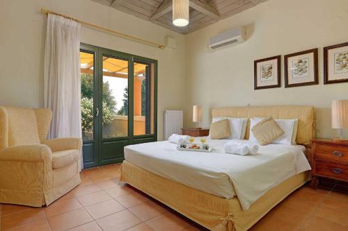 a bedroom with a large bed and a chair at Villa Riaki in Kaligata