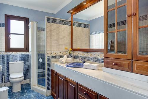 a bathroom with a sink and a toilet and a mirror at Villa Deu Quarterades in Santanyi