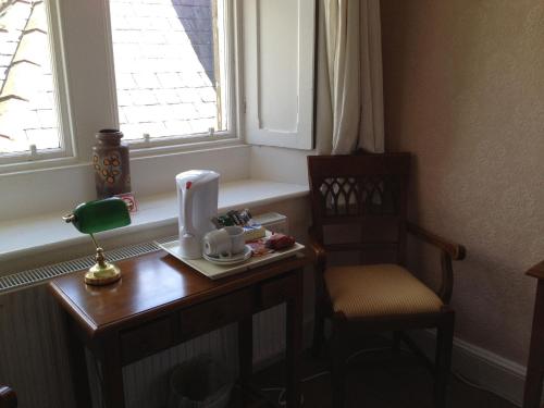a small table with a chair and a window at Clennell Hall Country House - Near Rothbury - Northumberland in Alwinton