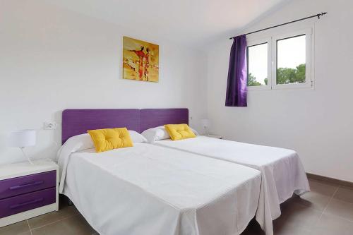 Un dormitorio con dos camas y una ventana. en Villa Son Gaieta, en Cala Galdana