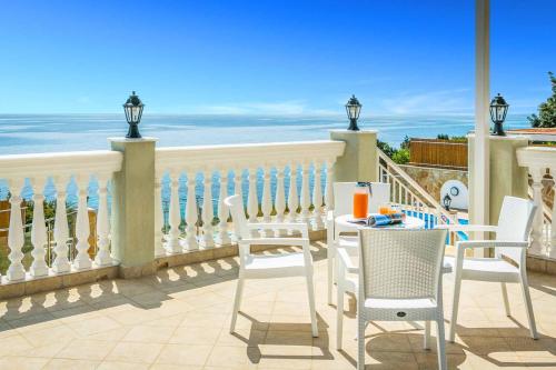 a table and chairs on a balcony with the ocean at Villa Azure in Spathíon