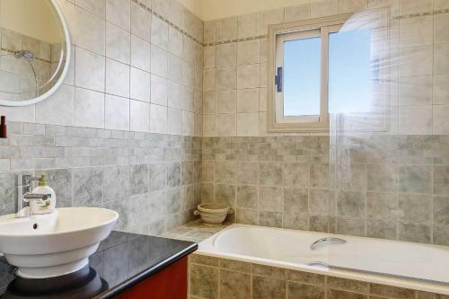 un baño con lavabo y bañera en Villa Yialos, en Neo Chorio