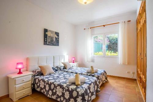 a bedroom with two beds and a window at Villa Paula in Cala'n Porter