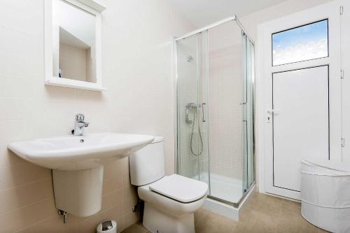 uma casa de banho com um lavatório, um WC e um chuveiro em Villa Alana em Es Mercadal