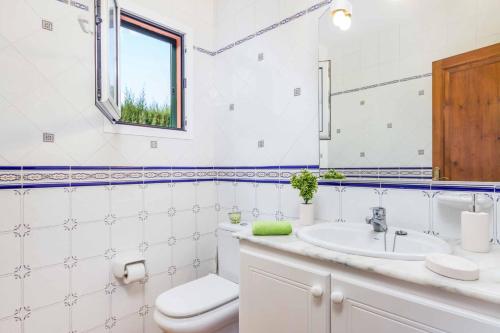 a bathroom with a sink and a toilet and a mirror at Villa Marcolis Mar in Cala Galdana