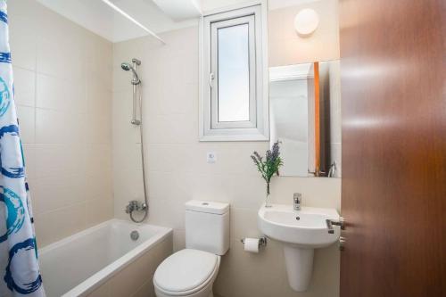 ein weißes Badezimmer mit Toilette und Waschbecken in der Unterkunft Villa White Daisy in Peyia