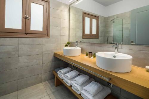 a bathroom with two sinks and towels on a counter at Villa Orchard in Ambelókipoi