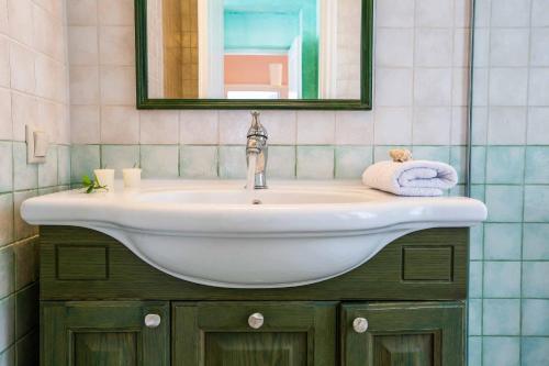 een wastafel met een spiegel en een handdoek bij Villa Agapi in Sivota