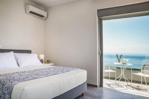 a bedroom with a bed and a balcony with the ocean at Villa Del Cielo in Vlachata