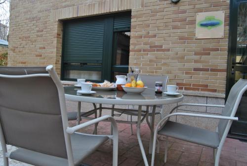 a table with a bowl of fruit on a patio at Apartahotel Rural CollaRubio Luxury in Collado Mediano