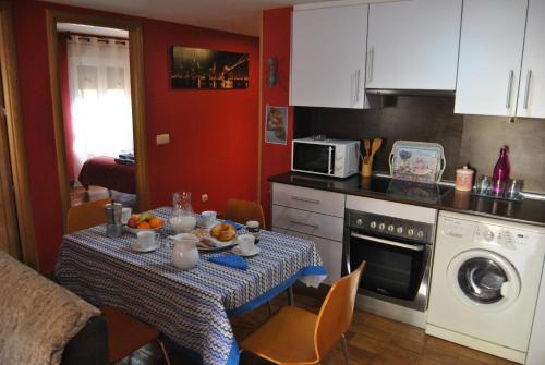 a kitchen with a table with a table cloth on it at Apartahotel Rural CollaRubio Luxury in Collado Mediano