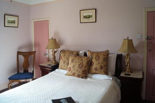 a bedroom with a bed and two lamps and a chair at Foundry Masters House in Ironbridge