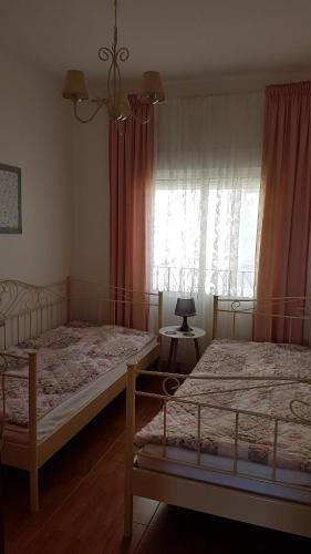 a bedroom with two beds and a window with curtains at Sol y Luz in Isla del Moral