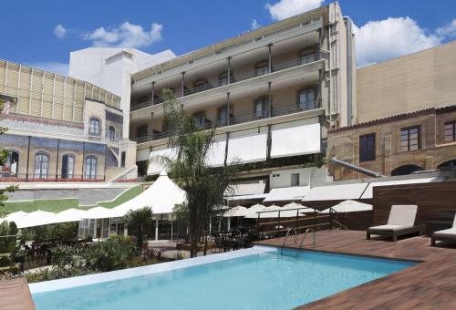 a hotel with a swimming pool in front of a building at Catalonia Portal de l'Angel in Barcelona