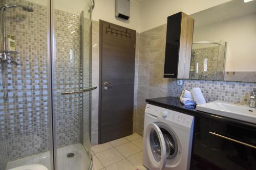 uma casa de banho com uma máquina de lavar roupa e um lavatório em F-Holiday Apartment em Zadar