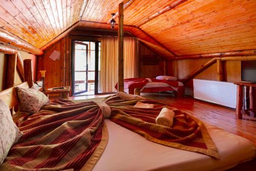 a large bed in a room with a wooden ceiling at Raiul de pe Rau in Moroeni