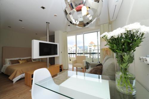 a living room with a bed and a vase of flowers at Duas Torres - Appartment in Funchal