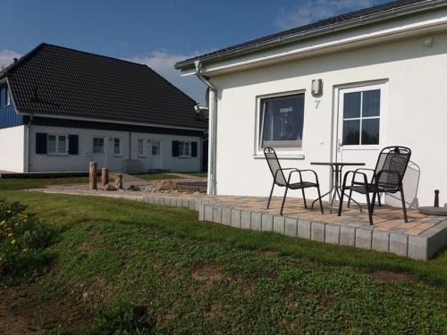 a patio with chairs and a table in front of a house at Altefähr in Altefähr