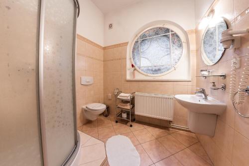 a bathroom with a toilet and a sink and a shower at Villa A. Malka in Poděbrady