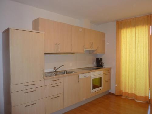 a kitchen with wooden cabinets and a sink at Abanico Ferien in Samnaun