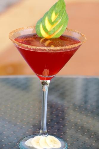 a red drink in a martini glass on a table at Coco Palm in Gros Islet
