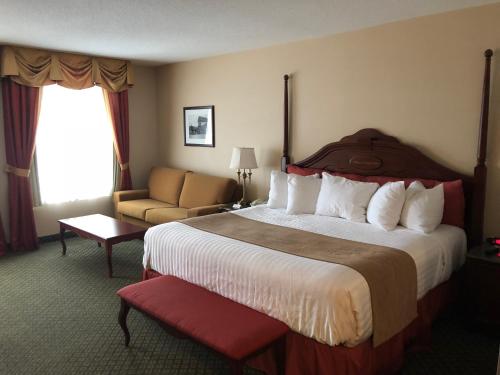 a hotel room with a large bed and a chair at Chateau Saint John Trademark Collection by Wyndham in Saint John