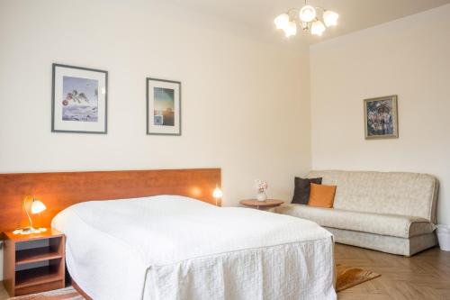 a bedroom with a white bed and a couch at Villa A. Malka in Poděbrady