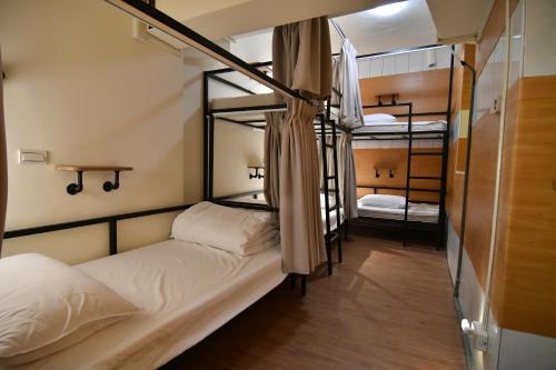a room with two bunk beds and a room with a table at Fuaowo Backpackers Homestay in Nangan